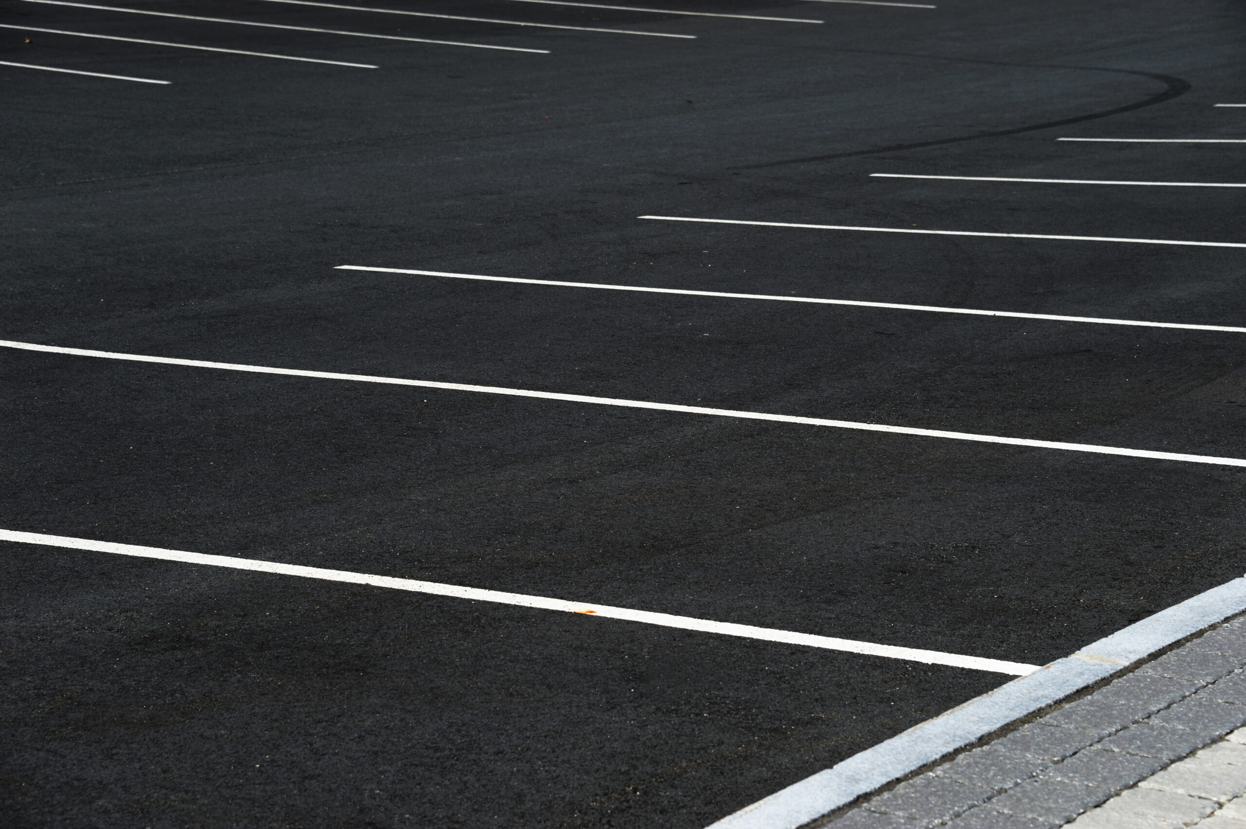 new paved empty parking lot with new painted strip lines